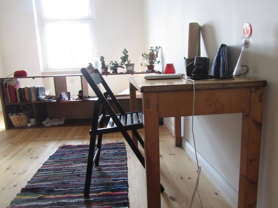 A beautiful wooden desk where you can set up your laptop station or even dine. Behind you can see a bookcase with space for your books and belongings. Books are of course up for reading!
