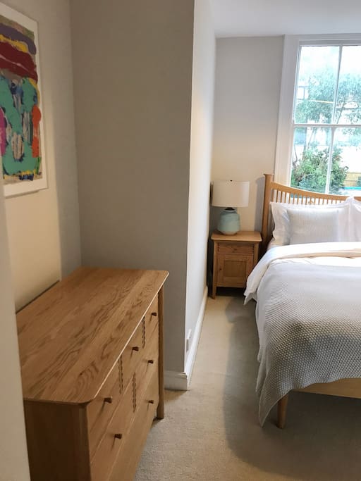 King size bed in bright, fresh bedroom.