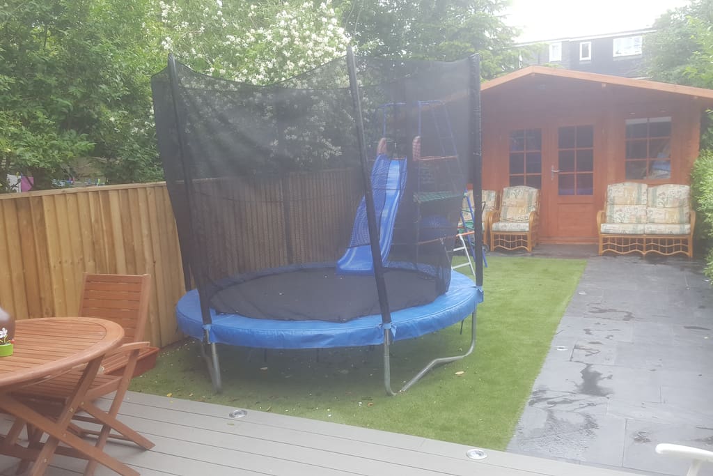 Backyard with patio and trampoline and slide