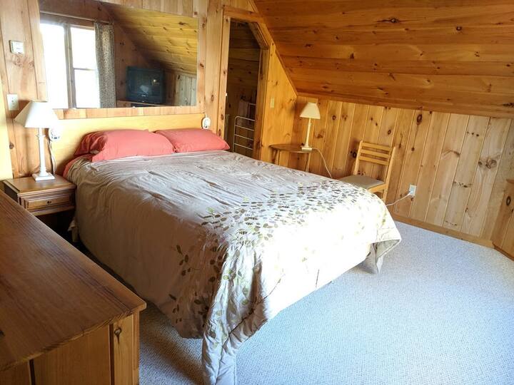bedroom with queen bed, air conditioner, and view of the lake