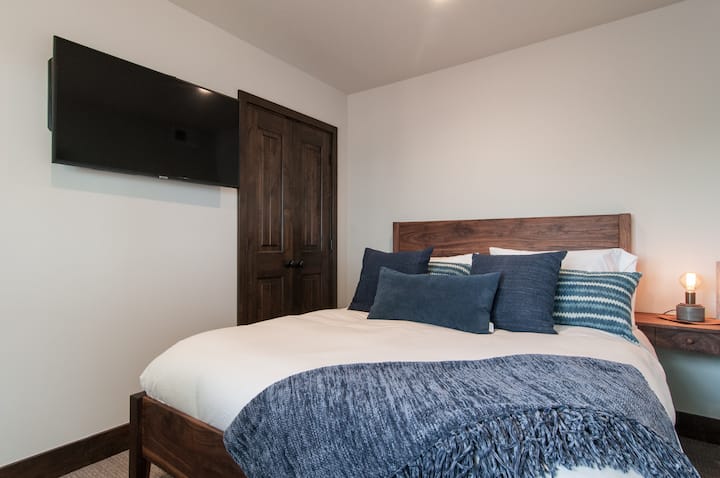 בחדר השינה השני יש מיטת קווין סייז והוא מצויד גם ברהיטי אגוזים מותאמים אישית ובגימורים כחולים של אינדיגו.