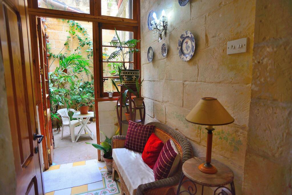 Sitting area outside the room either inside or outside under the plants and the Summer Sun.