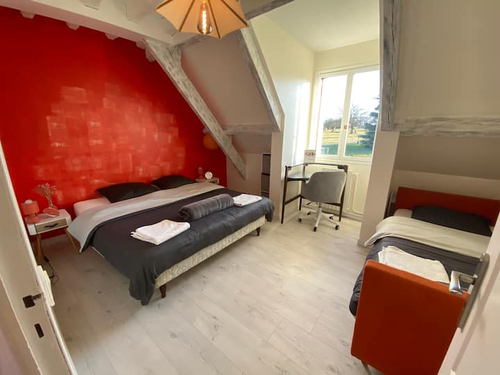 La chambre orange avec son lit double en 180 et son lit une personne (en 90). Salle de douche en face de la chambre  