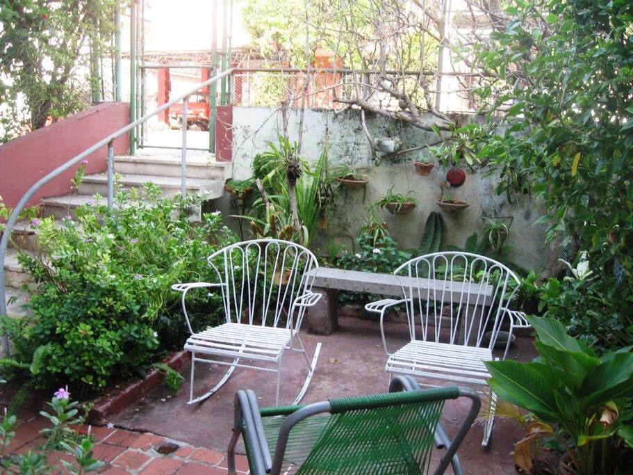 Portal con sillones y jardín.