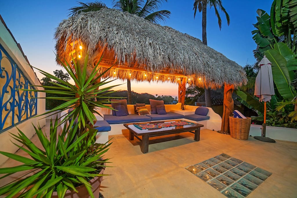 Poolside palapa at sunset with ocean views