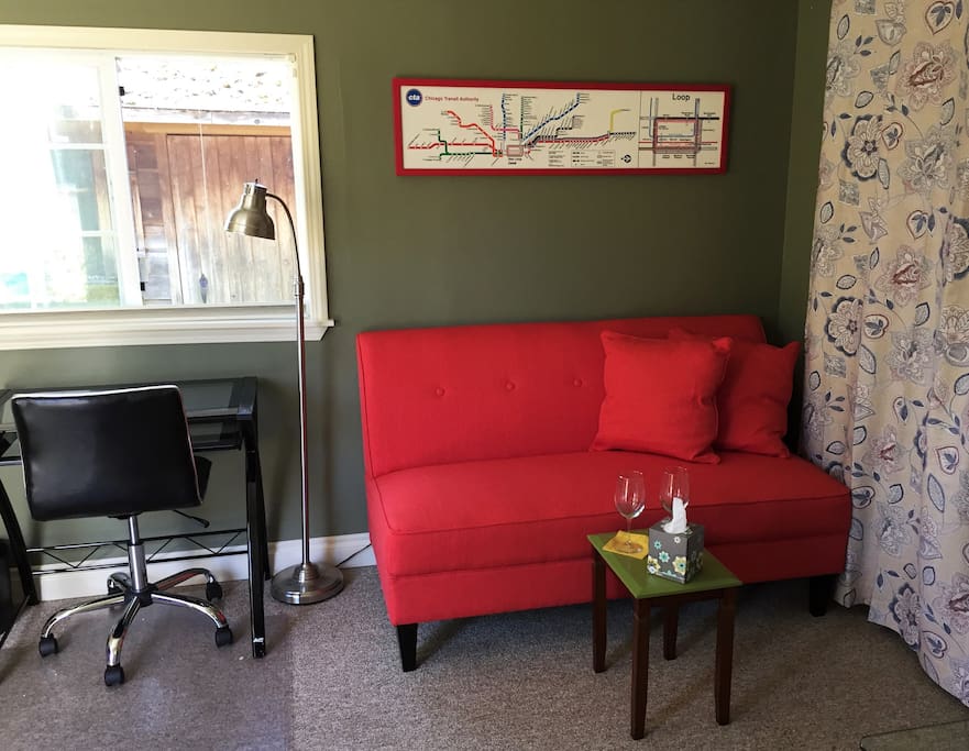 Living area with loveseat, entertainment center, and office desk and chair.