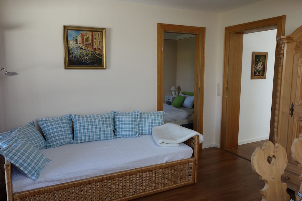 Ein Sofabett zum Ausruhen, Fernsehschauen oder zum Schlafen stehen im Wohnzimmer. Eine weitere Matraze für eine vierte Person kann dazugelegt werden.
