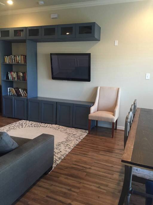 Living room features a mounted TV and custom built table.