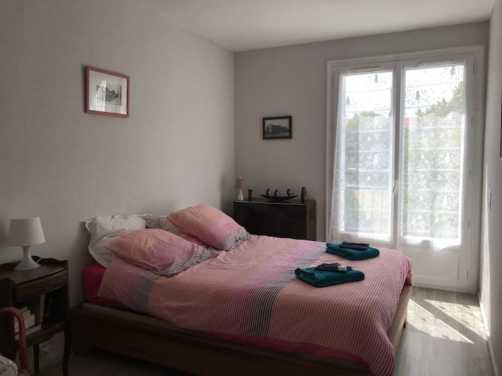 Hauptschlafzimmer mit Doppelbett, Nachttisch. Bettwäsche und Badetücher werden bereitgestellt.