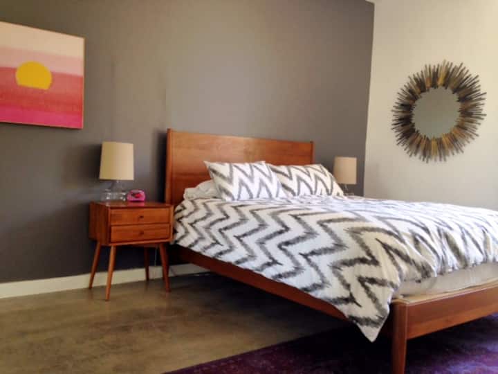 Spavaća soba s bračnim krevetom i TV-om ravnog ekrana.