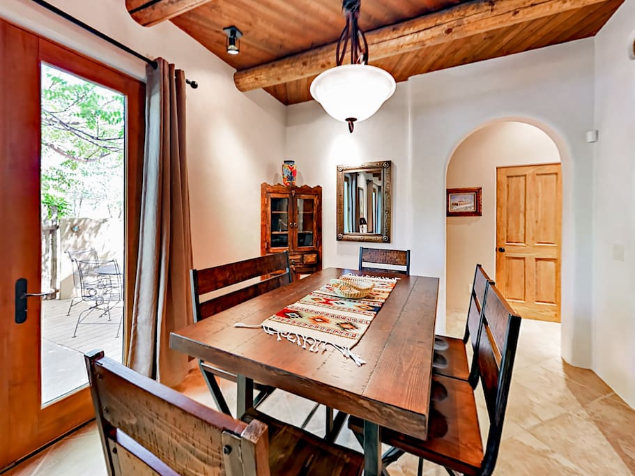 The dining room features a rustic wood table that can comfortably seat 6, as well as direct access to the private courtyard.