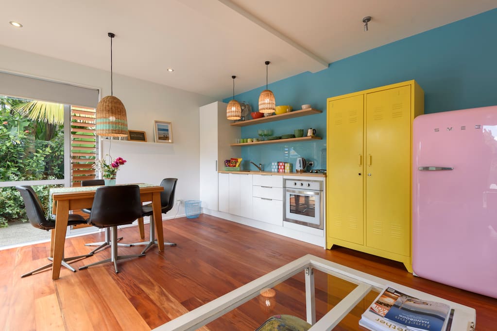 Living area with full stove, Smeg pink refrigerator, funky lights