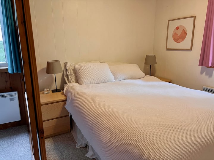 带标准双人床的卧室，由阁楼的滑动门隔开