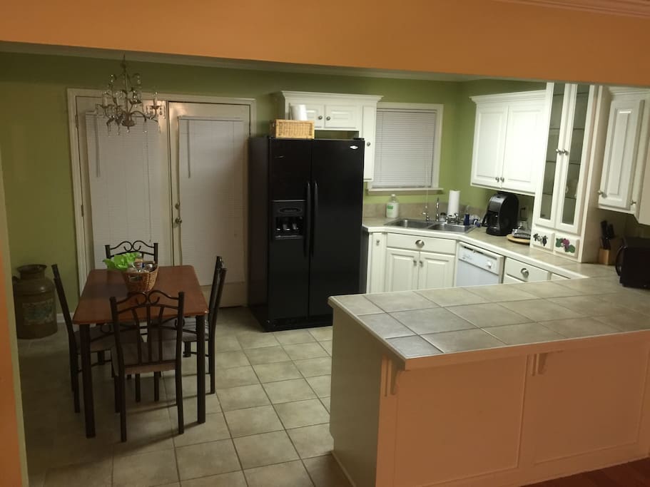 This is an updated photo of the kitchen showing the microwave, coffee pot, fridge and table.