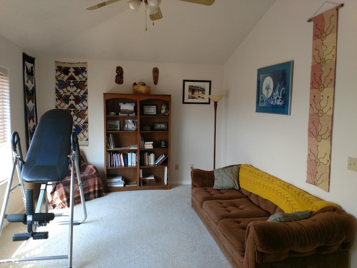 Chumba cha siku ya mbele na sofa kubwa kwa wageni wa ziada.