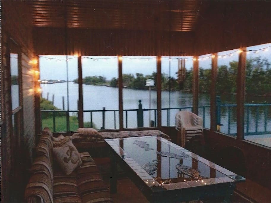 Screened porch w/large seating/table area and swinging bed