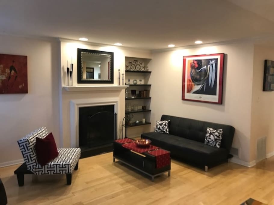 Living Room with fireplace. Black sofa folds flat to make an additional bed