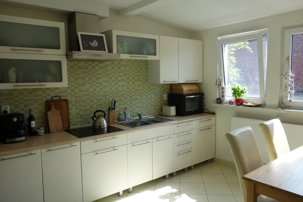 Shared opened kitchen with sofa and dining table