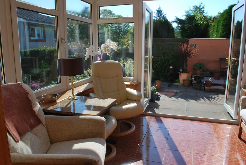 Large, sun-bathed conservatory with doors to patio