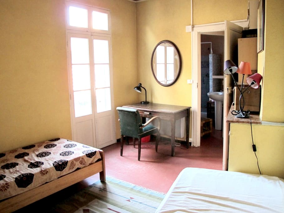 Chambre lumineuse et calme avec 2 lits individuels qui donnant sur salle de bain privée (toilettes et douche)
