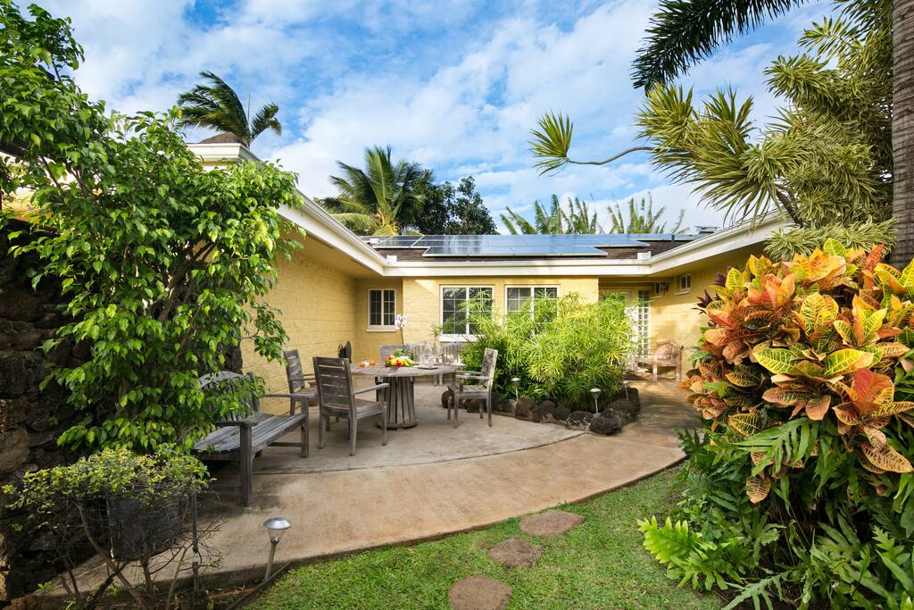 A large island home nestled within a lush tropical garden.