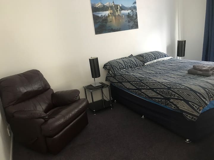Sovrum #2 med en dubbelsäng och förvaringsutrymme. Har också ett litet bord med en spegel