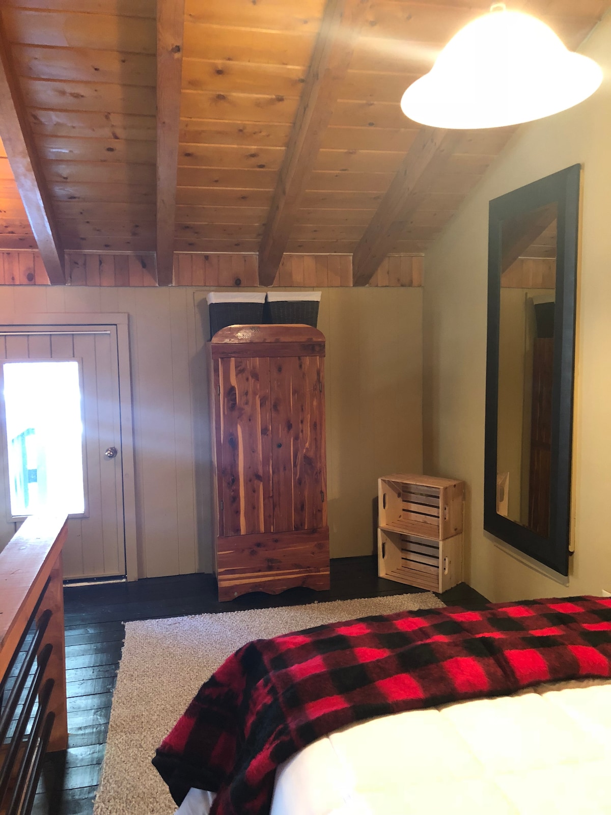 Spavaća soba u potkrovlju, zidno ogledalo pune dužine, bračni krevet, vrata na privatnu terasu u dvorištu.