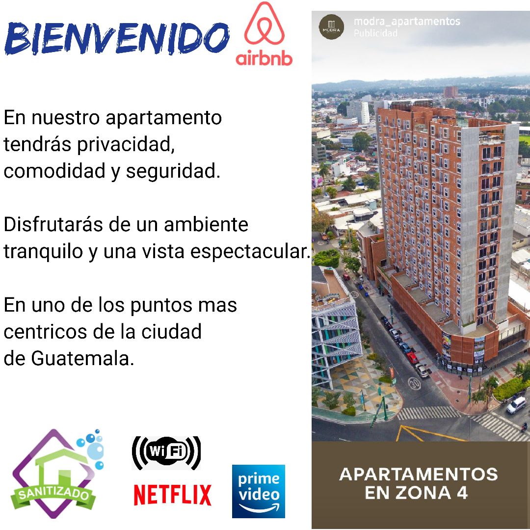 The building features modern architecture with a tall, multi-story façade. A panoramic view of the surrounding urban landscape is visible, showcasing city life. Branding elements and streaming service logos are displayed, indicating amenities available for guests.