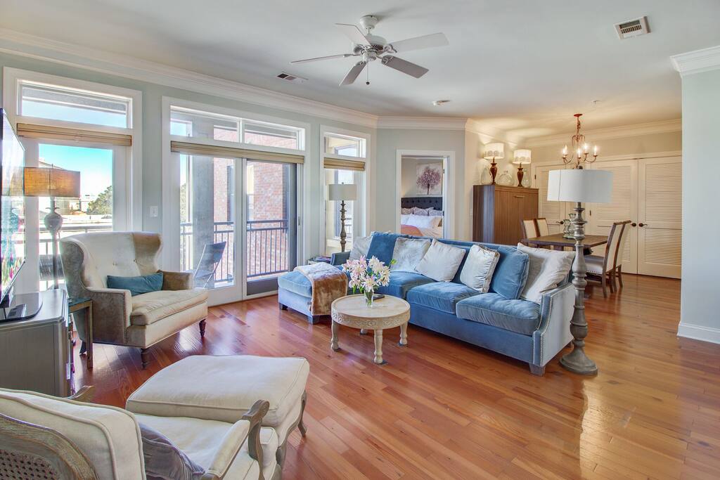 Gorgeous, bright and elegant great room complete with a velvet couch and French doors that lead out onto the terrace.