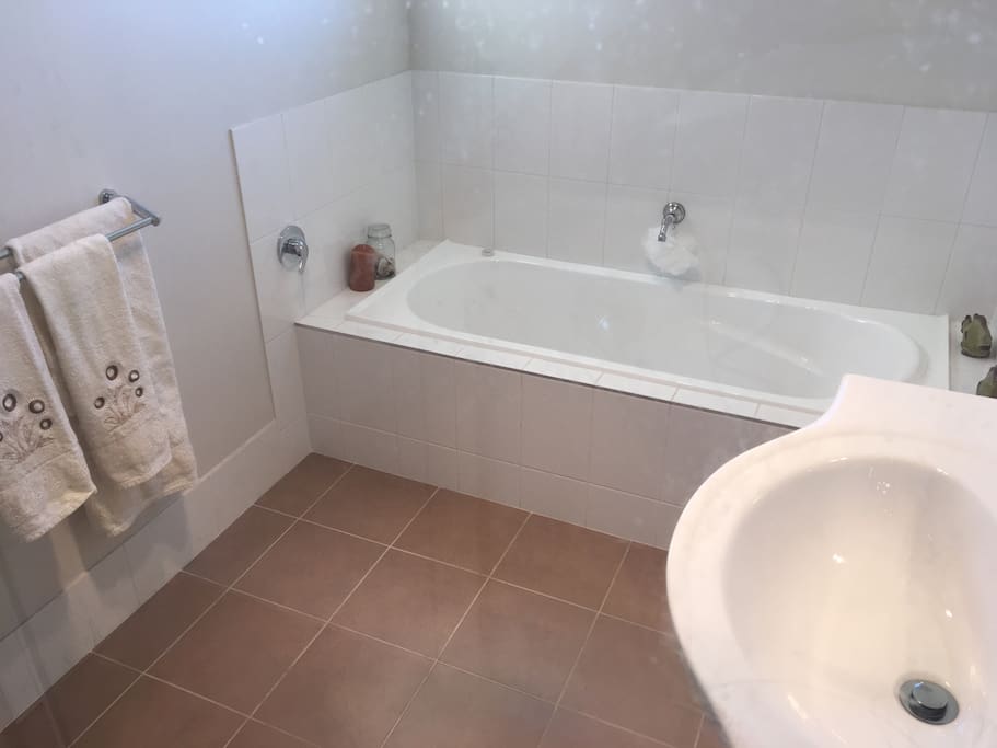 The guest bathroom is spacious with a bathtub and shower.