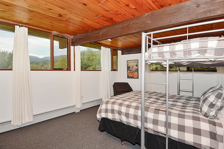 غرفة نوم كبيرة في الطابق السفلي مع سرير كوين وتوأم للأطفال