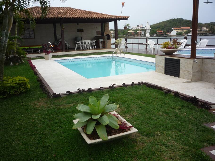 Vista da piscina, com churrasqueira ao foto. Rampa náutica com vistas para o canal