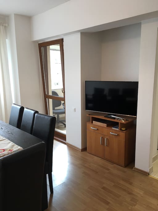 Part of the dinning room with the TV and the exit to the balcony.