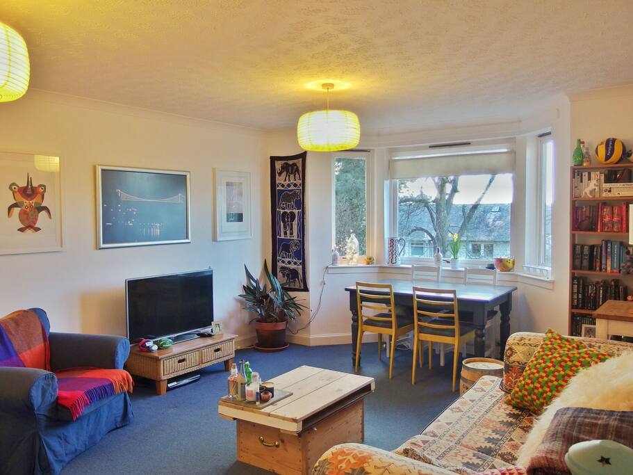 Communal living room with sofa, dining table and television.