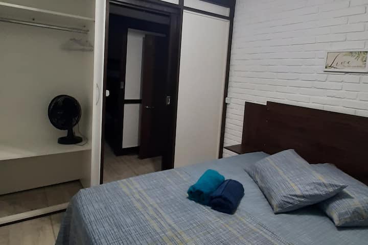 Dormitorio doble con cama de caja estándar y colchón Herval (escaleras de muelles) 138 cm x 188 cm. 
Cabecero de cama en mdf, con mesas auxiliares. Armario cerrado en mdf, con perchas y espacio para acomodar la ropa. Sábanas y fundas de almohada de microfibra.