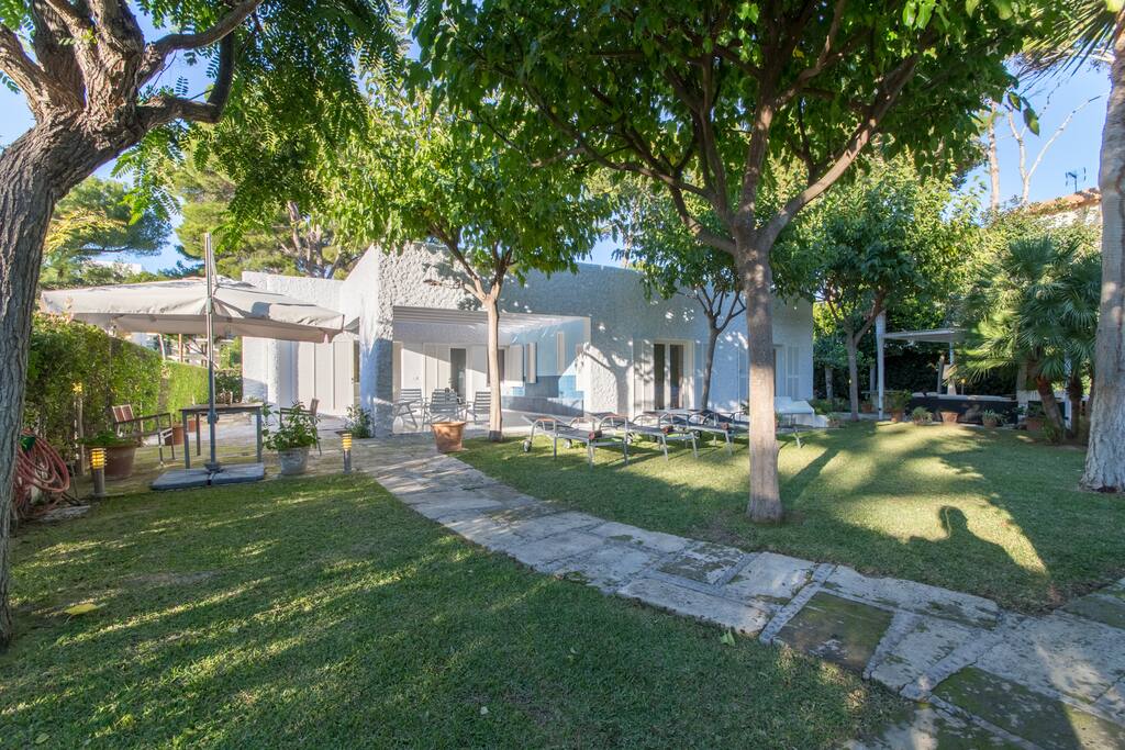 Outdoor area is designed with lots of green space and Mediterranean plants and trees.