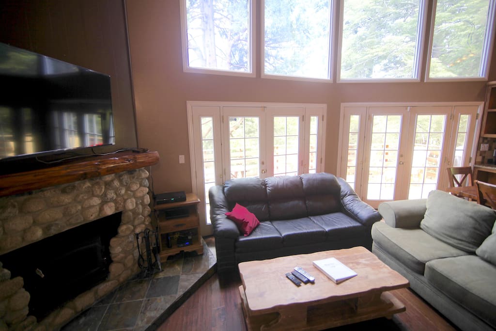Two sofas, flat screen TV and wood burning fireplace in living room