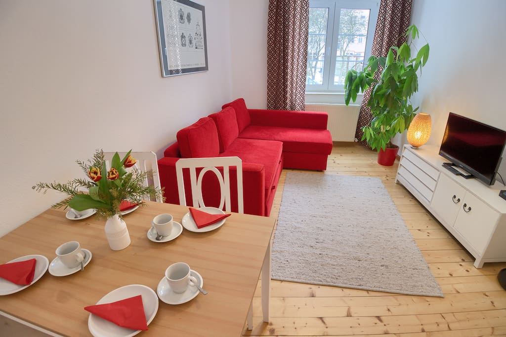 Wohnzimmer mit Schlafcouch und Esstisch