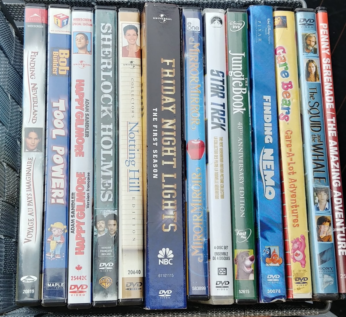 A collection of DVDs is organized in a case, showcasing various movie titles. The selection includes animated films, comedies, and dramas. Each DVD cover features colorful artwork and titles that are clearly displayed, providing options for a cozy movie night.