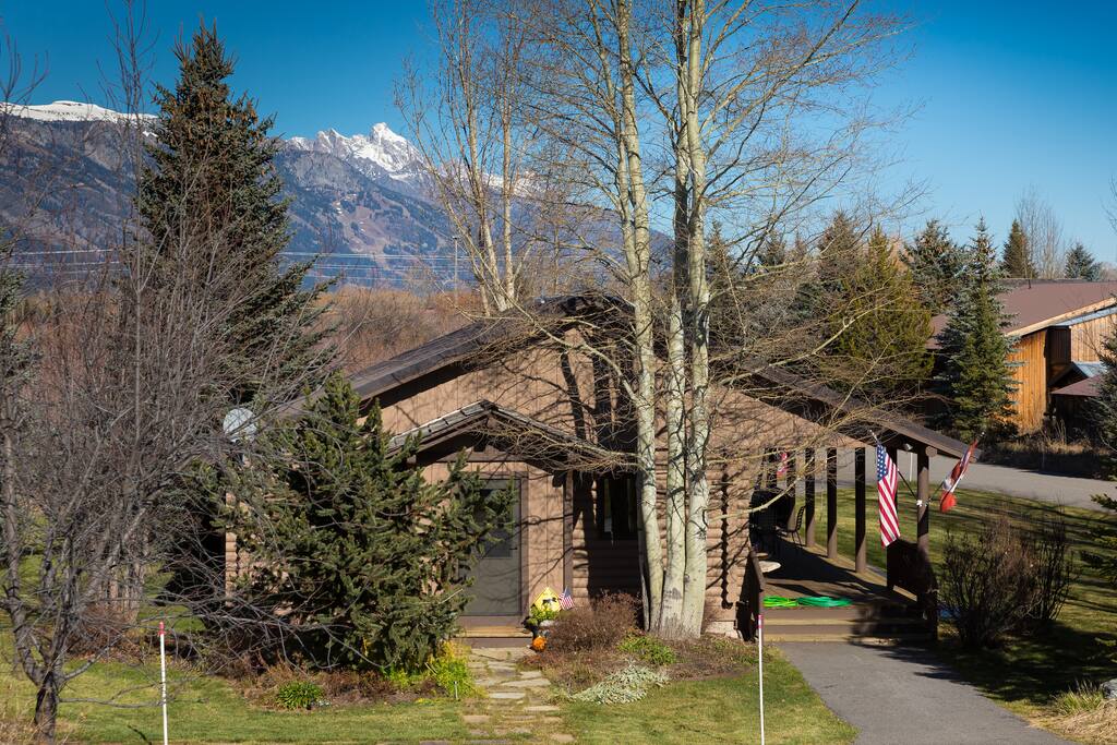 Front of cabin. Teton views. Open deck with seating.