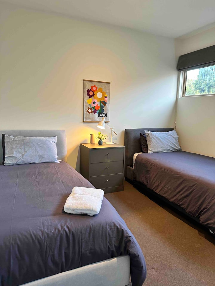 Vitanda viwili vya kifalme vya mtu mmoja na ukuta kamili wa makabati kwa ajili ya kuhifadhi. 