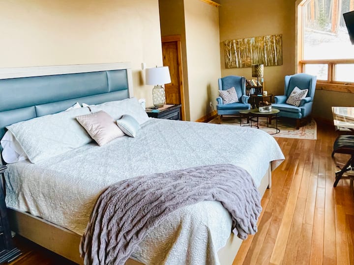 Голяма родителска спалня с двойно легло king size, кът за четене и зашеметяваща гледка към планината през панорамните прозорци