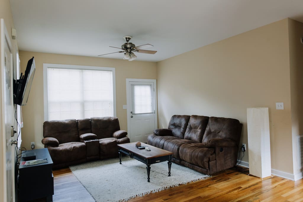 The living room is equipped with two luxurious sofas, each with individual electronically reclining seats. Kick back and relax!