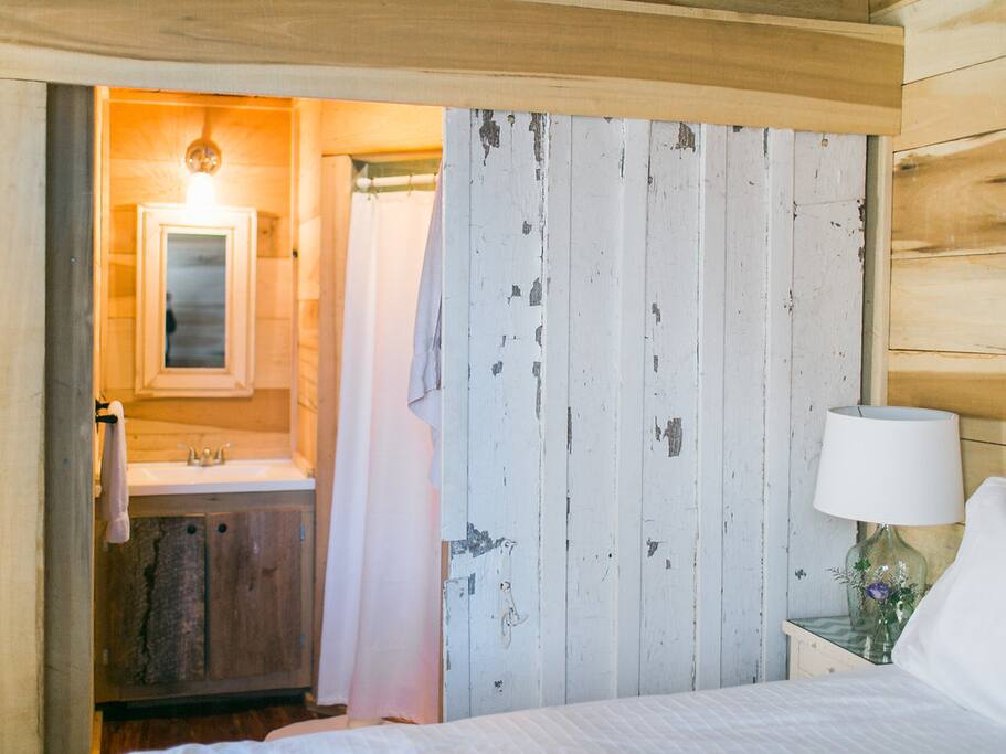Bathroom with shower, sink and toilet. Sliding door for privacy.