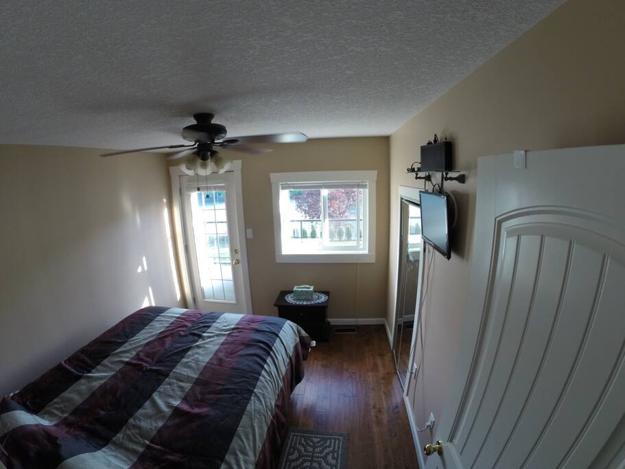 Main bedroom with back deck access and private entrance.Bed is a Queen with portable a/c in room and tv/basic cable