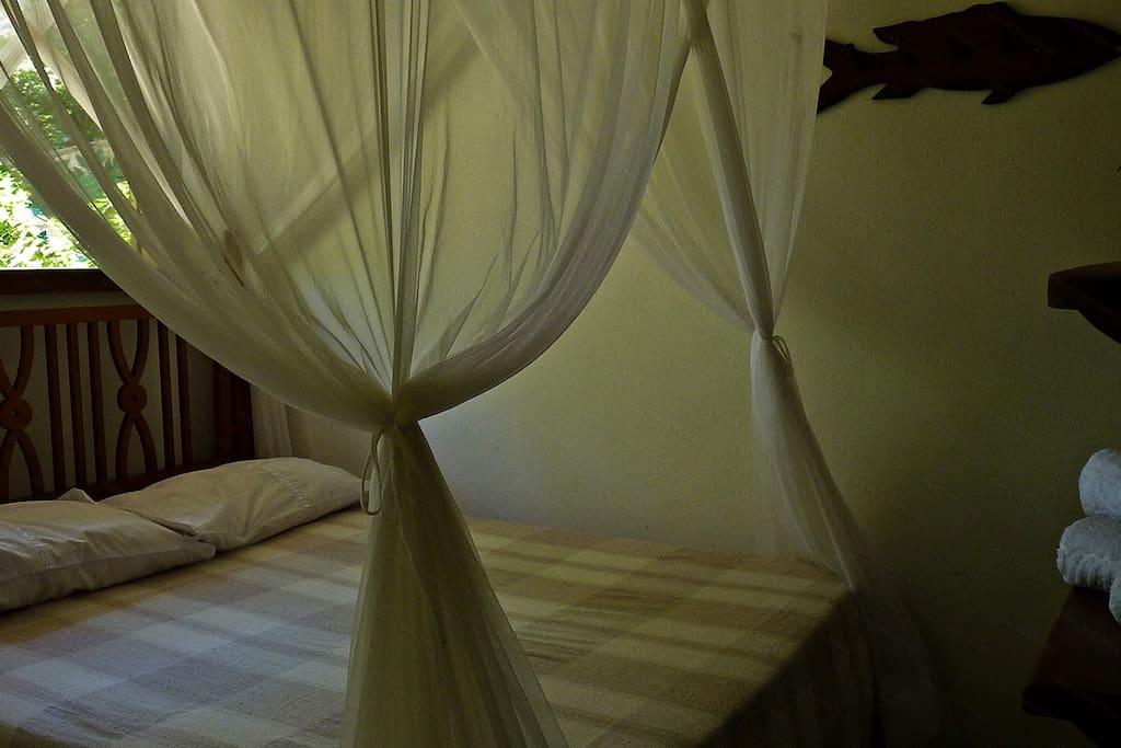 Vista do quarto com cama de casal.