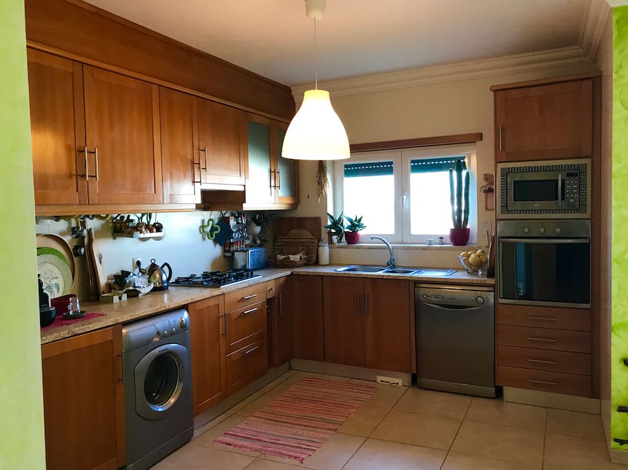 Cozinha e sala de refeições espaçosa, com boa luminosidade e ampla vista sobre parque de lazer e campo.