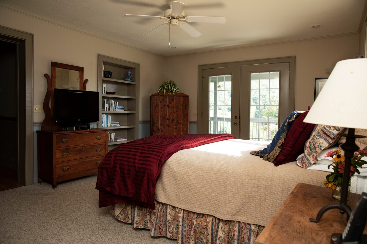 Hlavná spálňa má manželskú posteľ a francúzske dvere, ktoré sa otvárajú na verandu - ideálne miesto na prvú rannú šálku kávy alebo sledovanie, ako mesiac prechádza cez hory.
