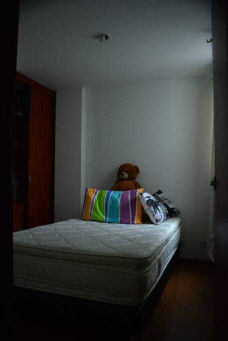 Bedroom with small double bed with private bathroom and a closet.
