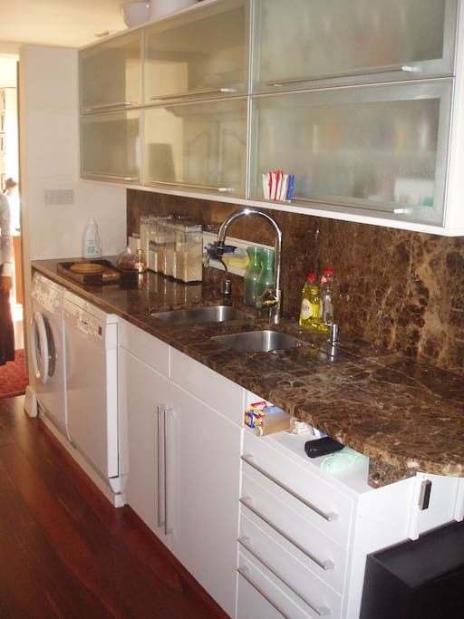 Kitchen with granite worktop and splashback, double sink and all basics foodstuffs - spices, dry herbs, cookbooks, etc
